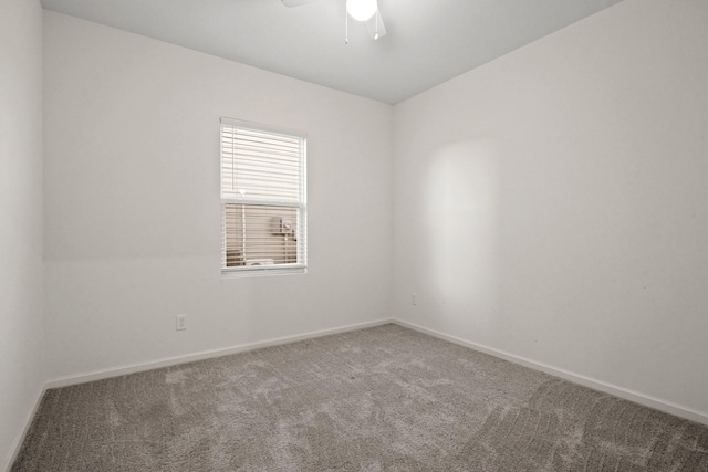 carpeted empty room featuring baseboards and ceiling fan