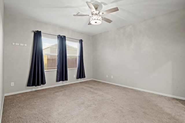 carpeted empty room with baseboards and a ceiling fan