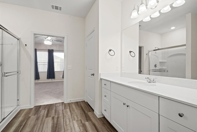 full bathroom with visible vents, a stall shower, wood finished floors, vanity, and a ceiling fan