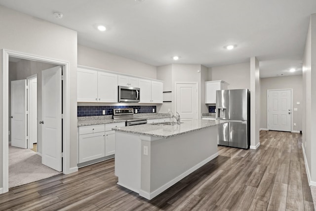 kitchen featuring white cabinets, a kitchen island with sink, appliances with stainless steel finishes, and a sink