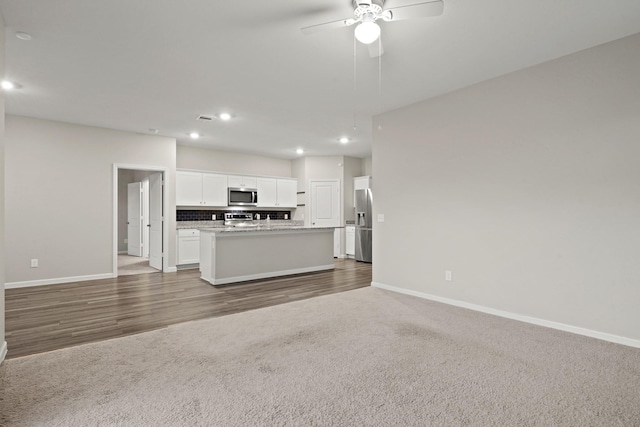 unfurnished living room with carpet flooring, recessed lighting, baseboards, and a ceiling fan