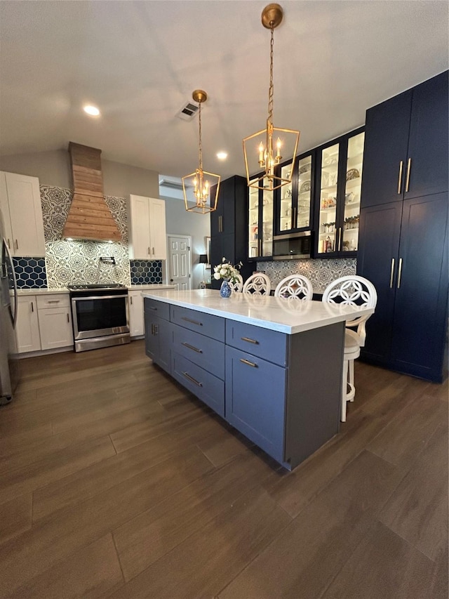 kitchen featuring a center island, light countertops, appliances with stainless steel finishes, an inviting chandelier, and custom exhaust hood