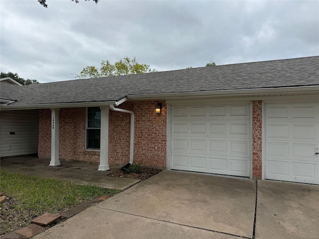 ranch-style house with concrete driveway, an attached garage, brick siding, and roof with shingles