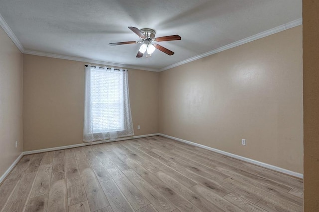 spare room with baseboards, crown molding, ceiling fan, and wood finished floors