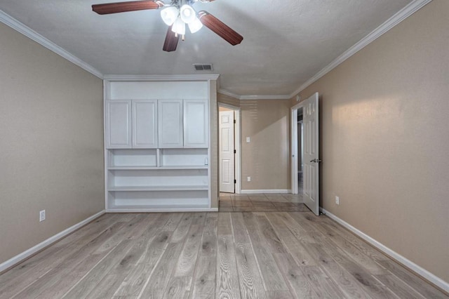 interior space featuring visible vents, light wood-style flooring, a ceiling fan, crown molding, and baseboards