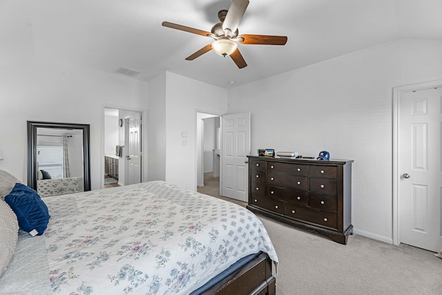 bedroom with a ceiling fan, visible vents, ensuite bath, vaulted ceiling, and light colored carpet