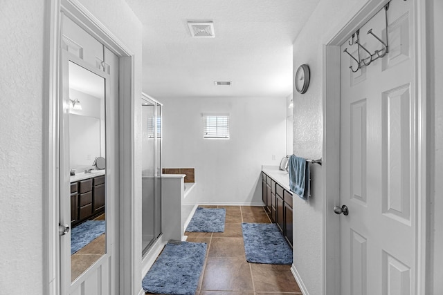 bathroom featuring vanity, a soaking tub, visible vents, and a stall shower