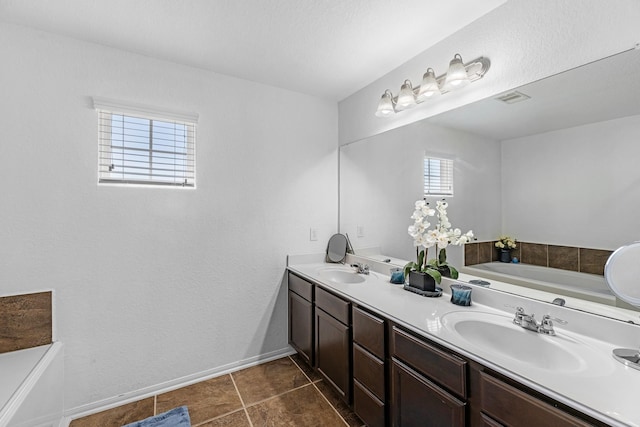 bathroom with a bath, visible vents, and a sink