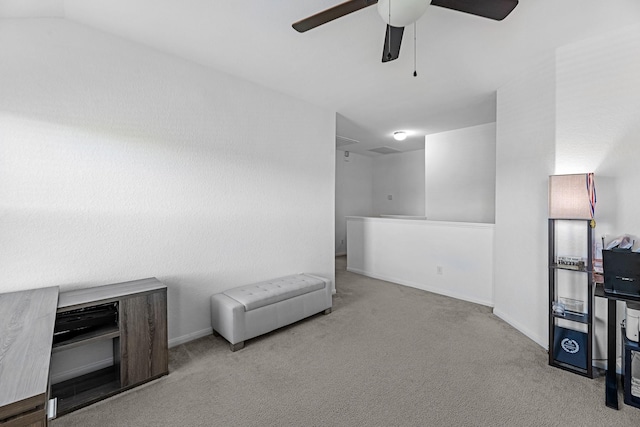 interior space featuring visible vents, lofted ceiling, a ceiling fan, carpet flooring, and baseboards