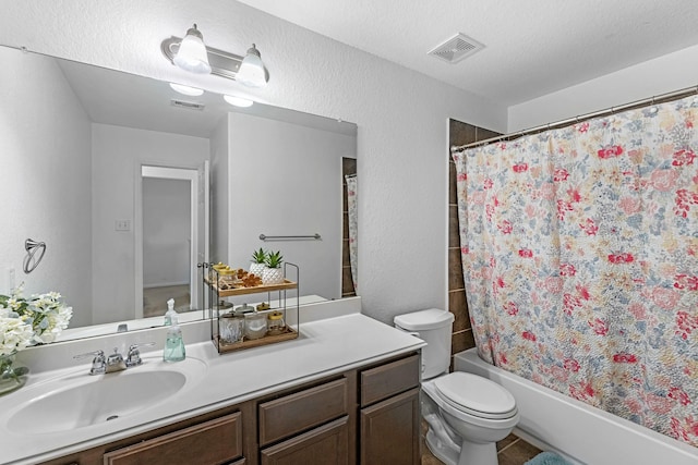 full bath with vanity, toilet, a textured wall, and visible vents