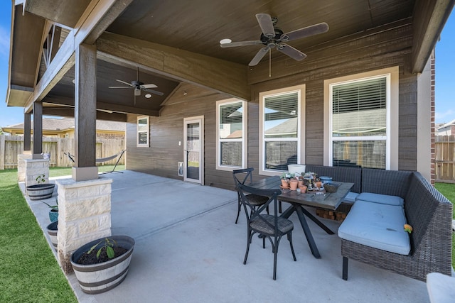 view of patio featuring ceiling fan, outdoor dining space, and fence