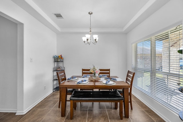 tiled dining area with visible vents, an inviting chandelier, baseboards, and a tray ceiling