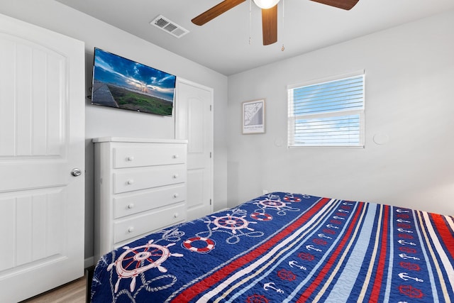 bedroom featuring wood finished floors, visible vents, and ceiling fan