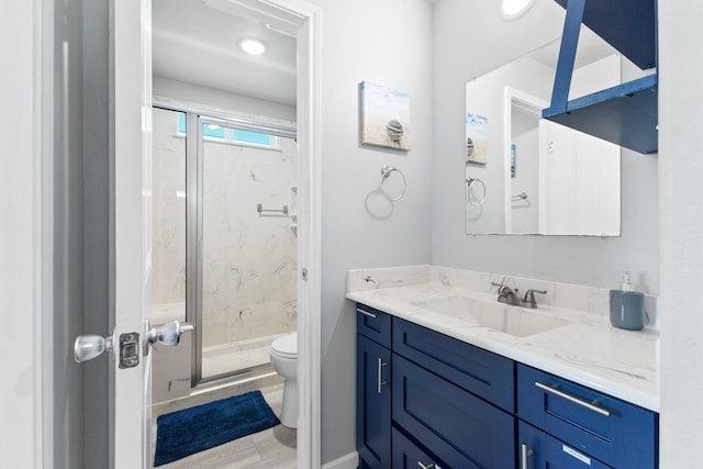 bathroom featuring a marble finish shower, toilet, and vanity