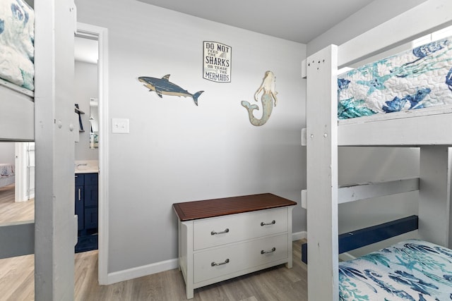 bedroom featuring baseboards and light wood finished floors