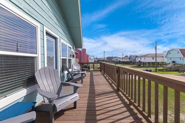 wooden terrace featuring a residential view and a yard