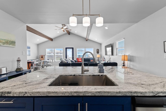 kitchen featuring open floor plan, blue cabinetry, and a sink