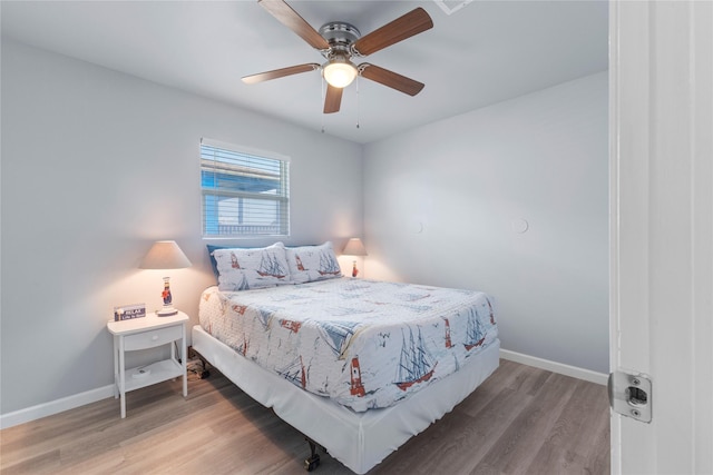 bedroom with baseboards, wood finished floors, and a ceiling fan