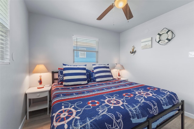 bedroom featuring ceiling fan, baseboards, and wood finished floors