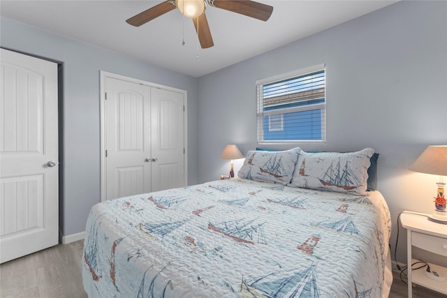 bedroom with baseboards, wood finished floors, a closet, and ceiling fan