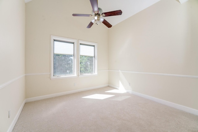 carpeted spare room with vaulted ceiling, baseboards, and ceiling fan