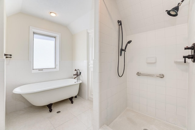 bathroom with tile patterned floors, a freestanding tub, tiled shower, and vaulted ceiling