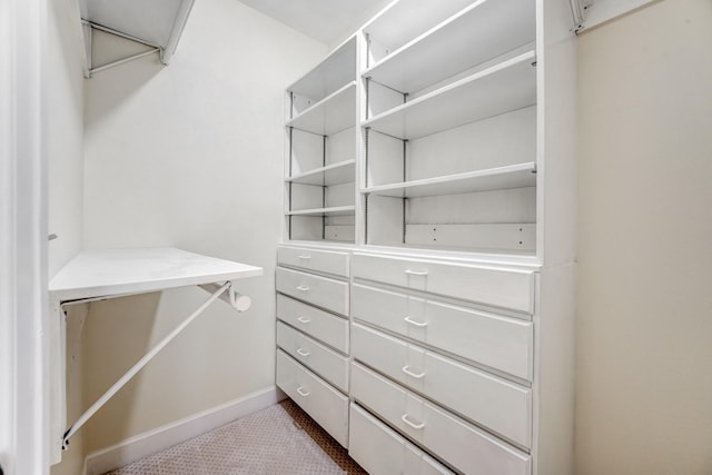 spacious closet featuring dark colored carpet