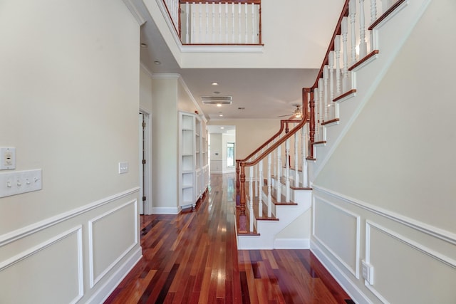 interior space with stairway, a decorative wall, visible vents, and hardwood / wood-style floors