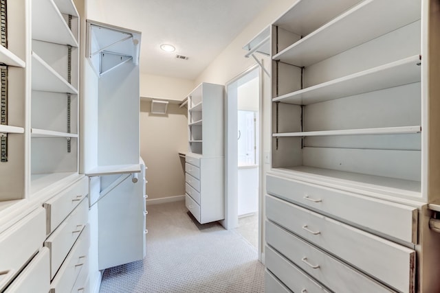 walk in closet with visible vents and light colored carpet