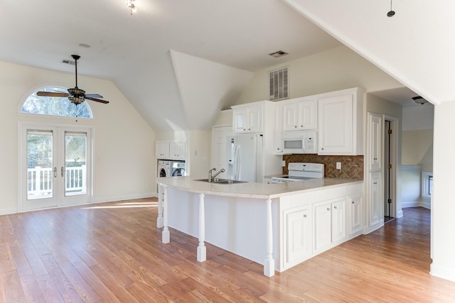 kitchen with light wood-style floors, white appliances, washing machine and dryer, and visible vents