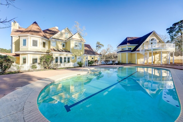 outdoor pool featuring fence