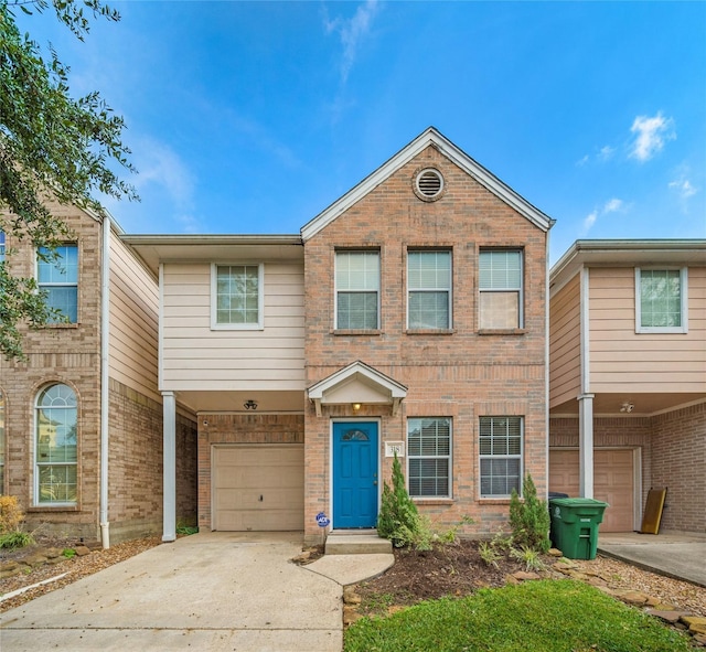 townhome / multi-family property featuring brick siding, an attached garage, and concrete driveway