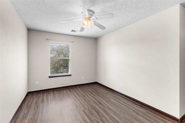 spare room featuring baseboards, wood finished floors, visible vents, and ceiling fan