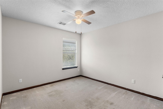 spare room with visible vents, ceiling fan, a textured ceiling, and carpet