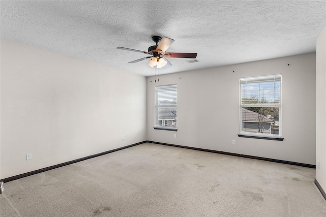 carpeted empty room featuring visible vents, baseboards, and ceiling fan