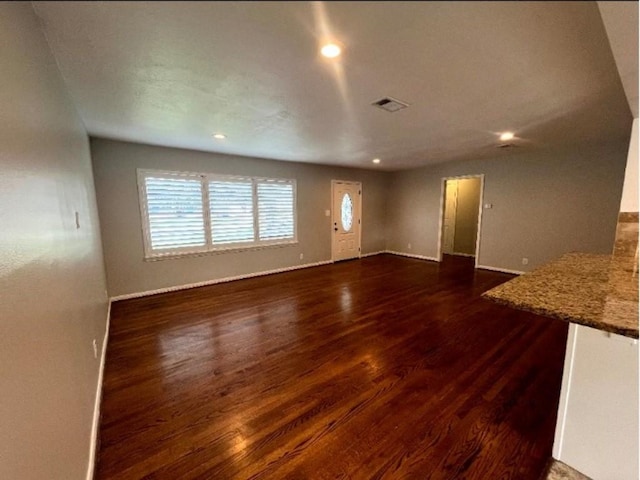 unfurnished living room featuring recessed lighting, visible vents, baseboards, and dark wood-style flooring