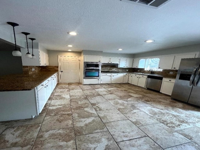 kitchen featuring decorative backsplash, appliances with stainless steel finishes, and white cabinets