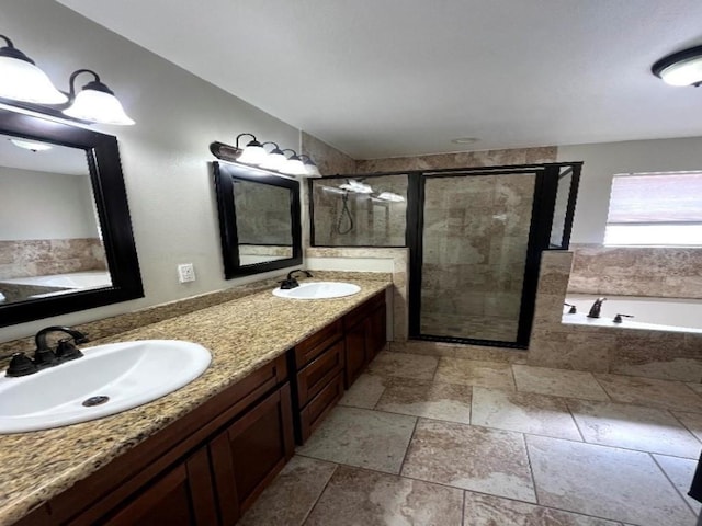 full bath with a garden tub, stone tile flooring, a shower stall, and a sink