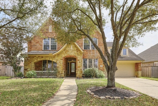 view of front of house with a front lawn, driveway, stone siding, fence, and a garage