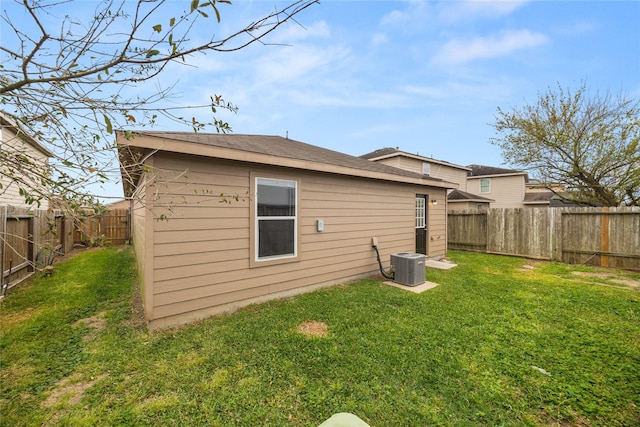 back of property with a yard, cooling unit, and a fenced backyard