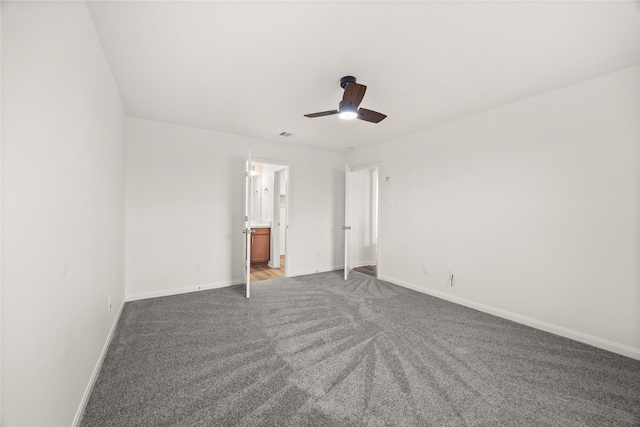 unfurnished bedroom featuring connected bathroom, baseboards, and carpet