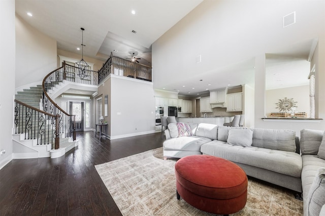 living area with baseboards, stairway, recessed lighting, a high ceiling, and dark wood-style flooring