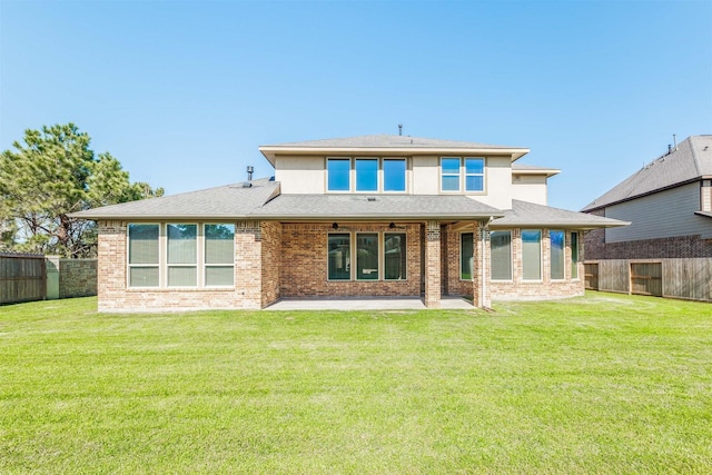 rear view of property featuring a patio, brick siding, and a fenced backyard