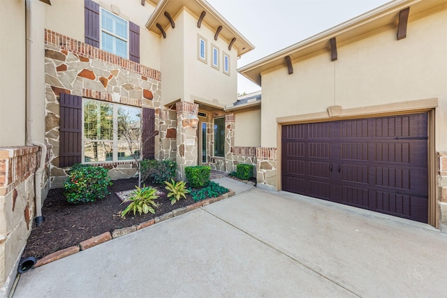 view of front of property with concrete driveway, a garage, stone siding, and stucco siding