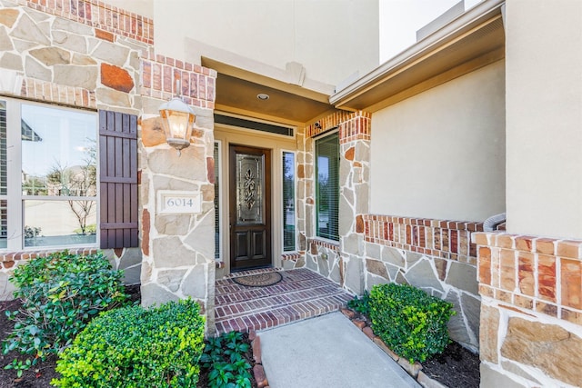 property entrance featuring stone siding and stucco siding