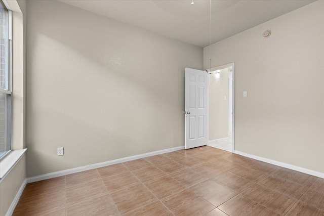 spare room featuring a healthy amount of sunlight and baseboards