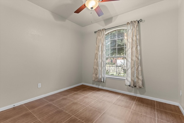 spare room featuring baseboards and ceiling fan