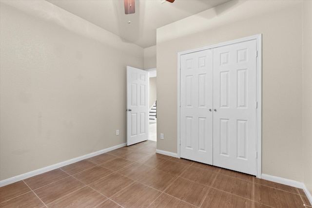 unfurnished bedroom featuring a ceiling fan, baseboards, and a closet