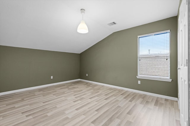 bonus room featuring visible vents, light wood-type flooring, baseboards, and vaulted ceiling