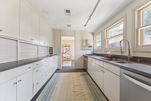 kitchen featuring visible vents, a sink, white cabinets, rail lighting, and appliances with stainless steel finishes